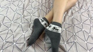 Girl with long legs caresses her feet in gray New Year socks with deer - porn video